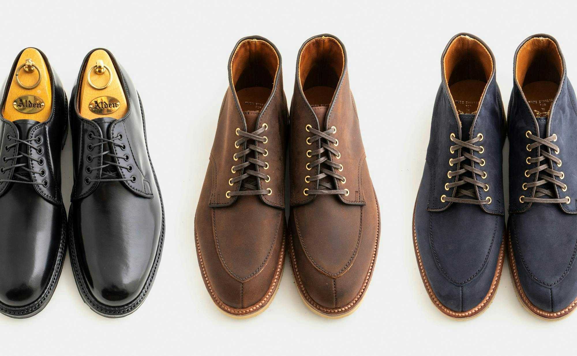 A pair of black derbys, a pair of brown chukka boots, and a pair of navy chukka boots.